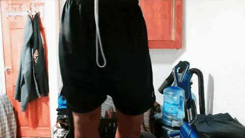 a person wearing black shorts is standing in a room