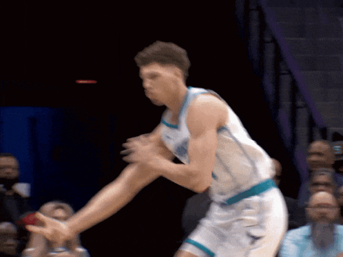 a basketball player in a white jersey with a blue stripe