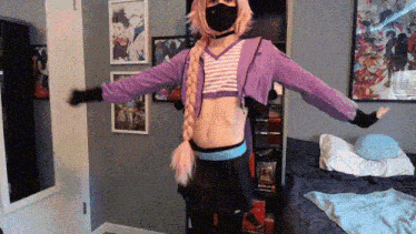 a person in a cosplay costume is standing in a bedroom with their arms outstretched and wearing a mask .
