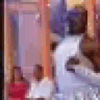a blurry picture of a woman in a red dress standing next to a table .