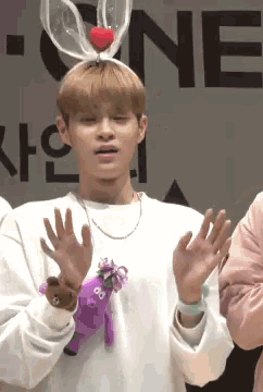 a young man wearing a bunny ear headband with a heart on it