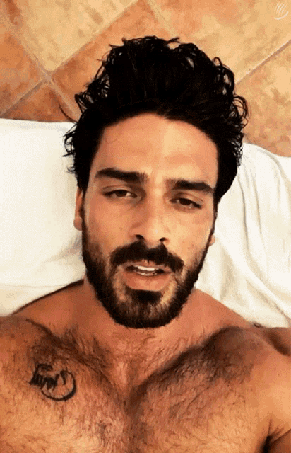 a shirtless man with a beard has a tattoo on his chest that says ' i love you '