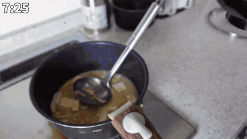 a pot of food is being cooked on a stove with the time of 7:25