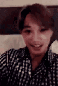 a close up of a person wearing a plaid shirt and smiling .