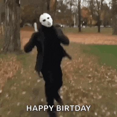 a person in a halloween costume is running in a park while wearing a mask .