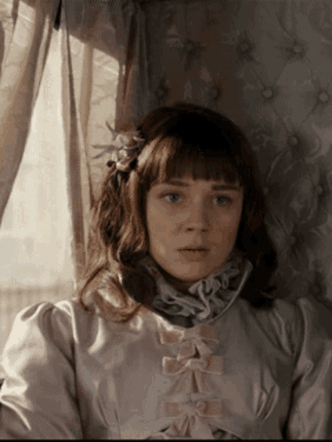 a girl with a flower in her hair looks at the camera