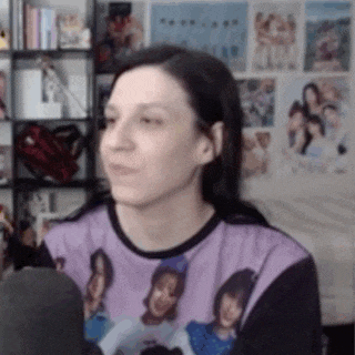 a woman is sitting in front of a microphone wearing a purple shirt with a picture of herself on it .