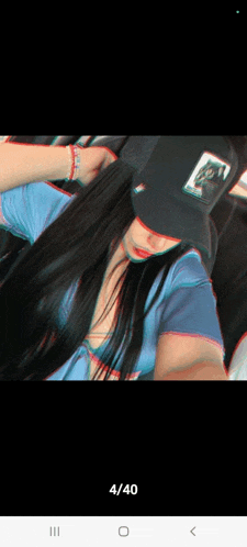 a woman wearing a hat with a picture of a cat on it takes a selfie