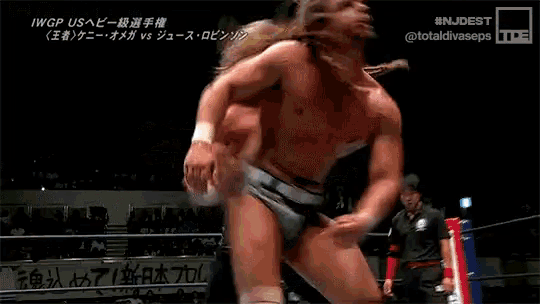 a wrestling match is being shown in a foreign language with a pepsi ad in the background