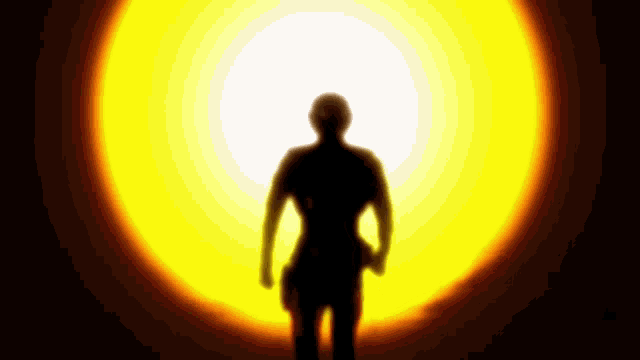 a silhouette of a man standing in front of a bright yellow light