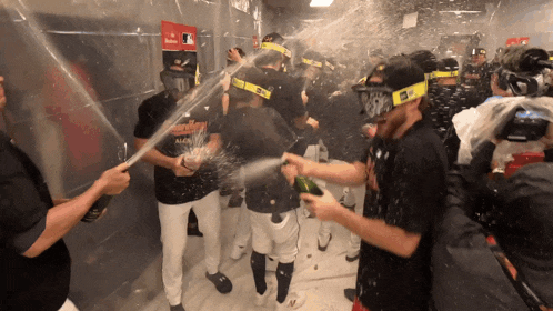 a group of baseball players are celebrating a win with champagne