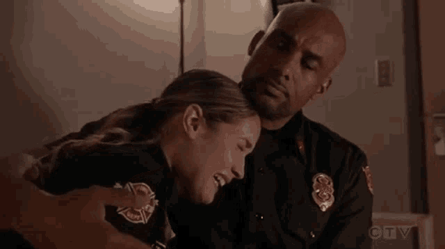 a man is holding a woman 's head in his arms .