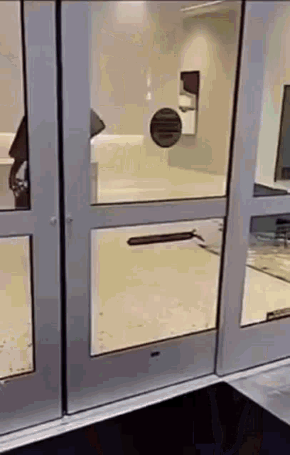 a person is standing in front of a glass door in a building .