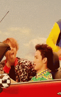 a group of people in a red car with a soccer ball in the back seat