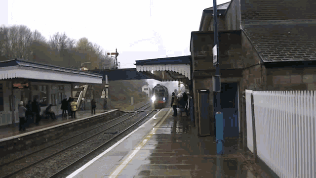 a train station with people waiting and a sign that says ' a ' on it