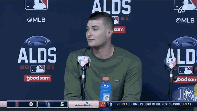 a man with a gatorade bottle in front of a sign that says aldos