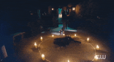 a close up of a person 's face with a candle in the background