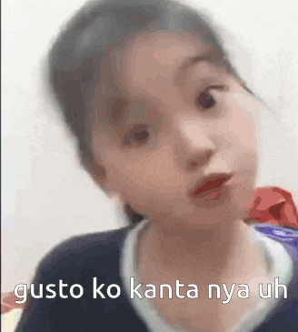 a little girl is making a funny face with the words gusto ko kanta nya uh written next to her .