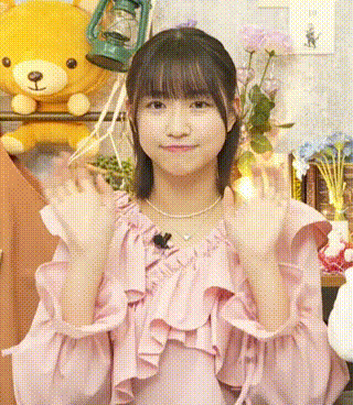 a young girl in a pink dress is standing in front of a teddy bear and a lamp .