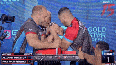 two men arm wrestling in front of a gold star coffee sign