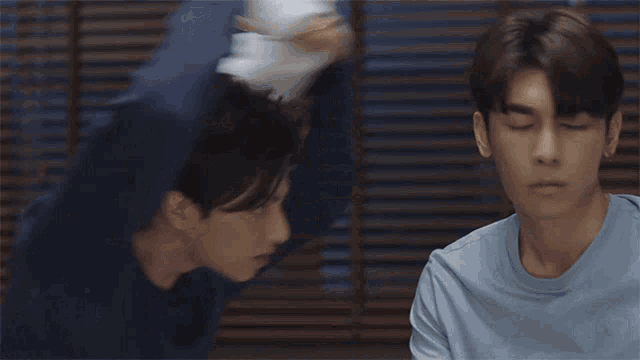 two young men are looking at each other with a towel around their necks