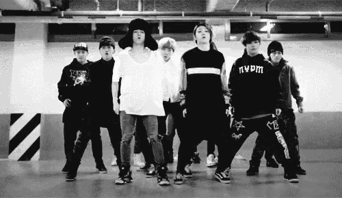 a black and white photo of a group of young men standing next to each other in a room .