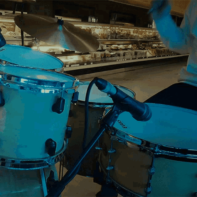 a person playing drums in a store with a microphone that says ' sd ' on it