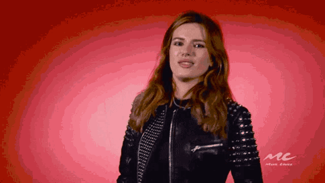 a woman wearing a leather jacket with studs on the sleeves