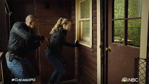 a man and a woman are standing in front of a door with the chicagopd logo on the bottom