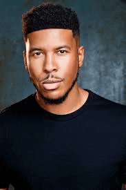 the man is wearing a black shirt and looking at the camera .