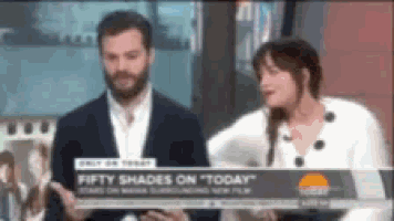 a man and a woman are standing next to each other in front of a sign that says fifty shades on today