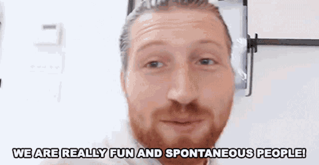 a man with a beard is making a funny face and says we are really fun and spontaneous people .
