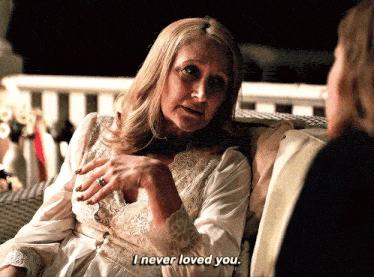 a woman sitting on a couch talking to another woman who says i never loved you