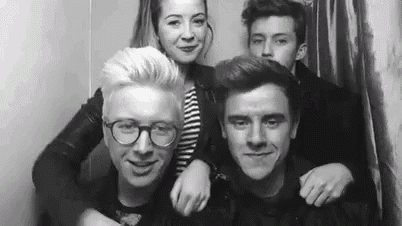 a black and white photo of a group of people posing for a picture in a photo booth .
