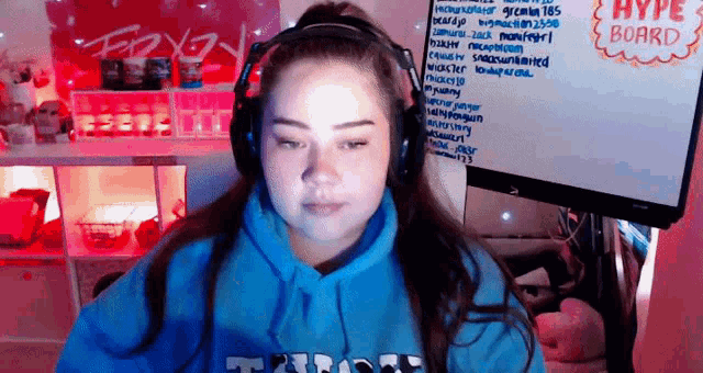 a woman wearing headphones is sitting in front of a white board with the word hype on it