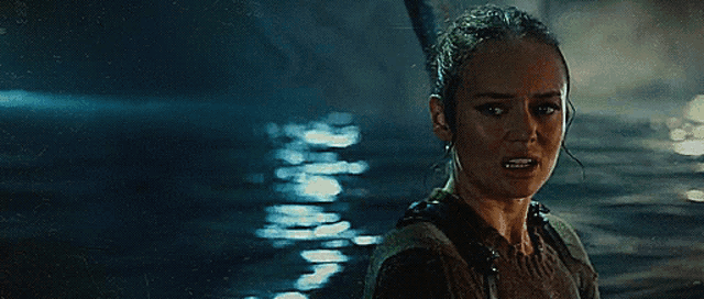 a woman is standing in the water with her mouth open and looking at the camera .