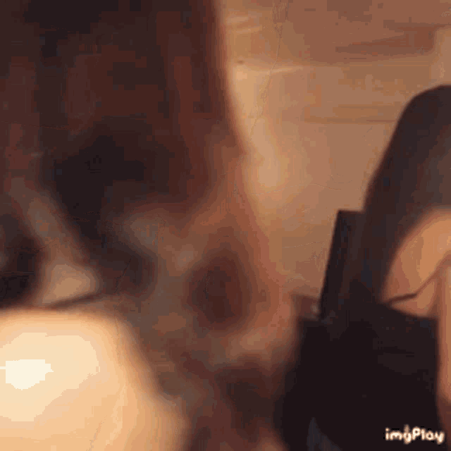 two women are standing next to each other in a room . one of the women is wearing a mask .