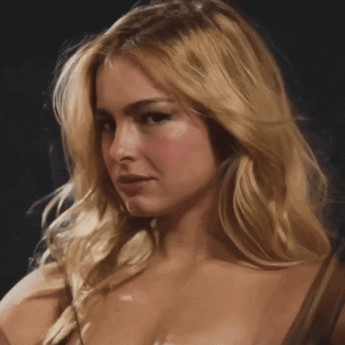 a close up of a blonde woman 's face with a dark background