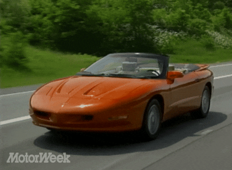 an orange sports car is driving down a road with motorweek written on the bottom right