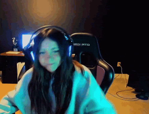 a girl wearing headphones is sitting in a gaming chair with the word riot on it