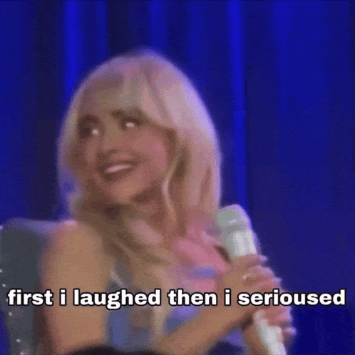 a woman is holding a microphone and saying first i laughed then i serious