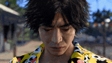 a close up of a man 's face wearing a yellow shirt with mickey mouse on it