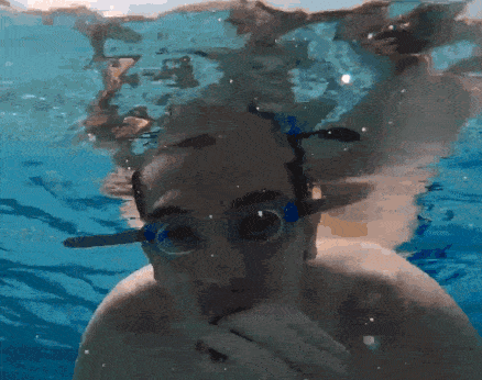 a man wearing goggles is underwater in a pool