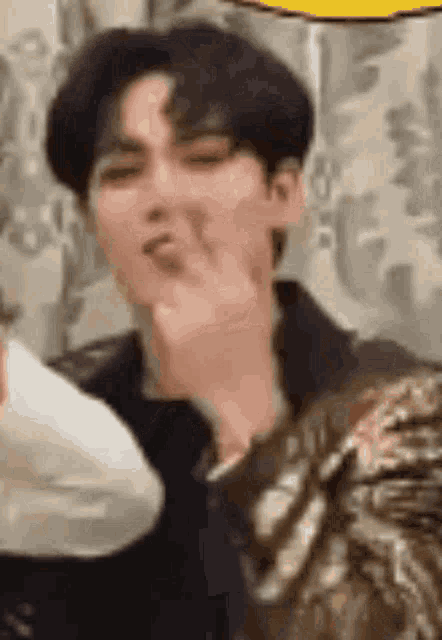 a close up of a person making a funny face with their hand .