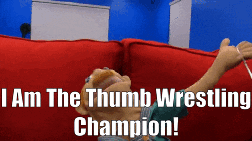 a puppet laying on a red couch with the words " i am the thumb wrestling champion "