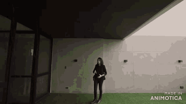 a woman standing in front of a building with the words made in animotica on the bottom right