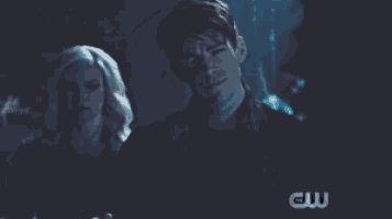 a close up of a man in a dark room with a cw logo in the corner