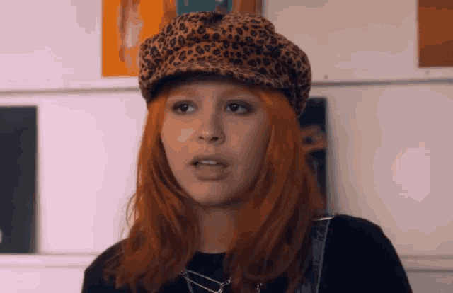 a woman with red hair wearing a leopard hat