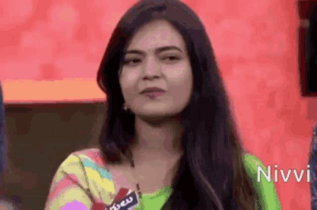 a woman with long hair is wearing a green and yellow striped shirt .