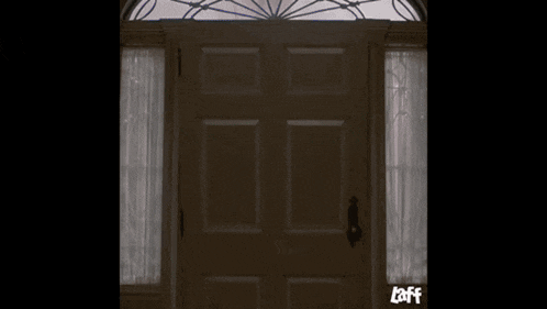 a man wearing a hat with a skull on it is standing in an open doorway